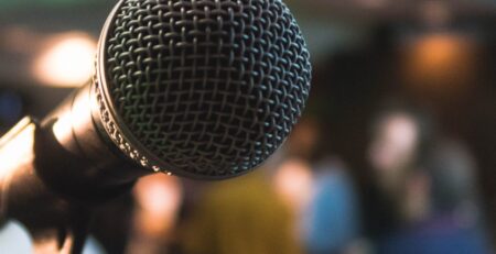 A microphone before a crowd of people, waiting for a speech on personal brand.
